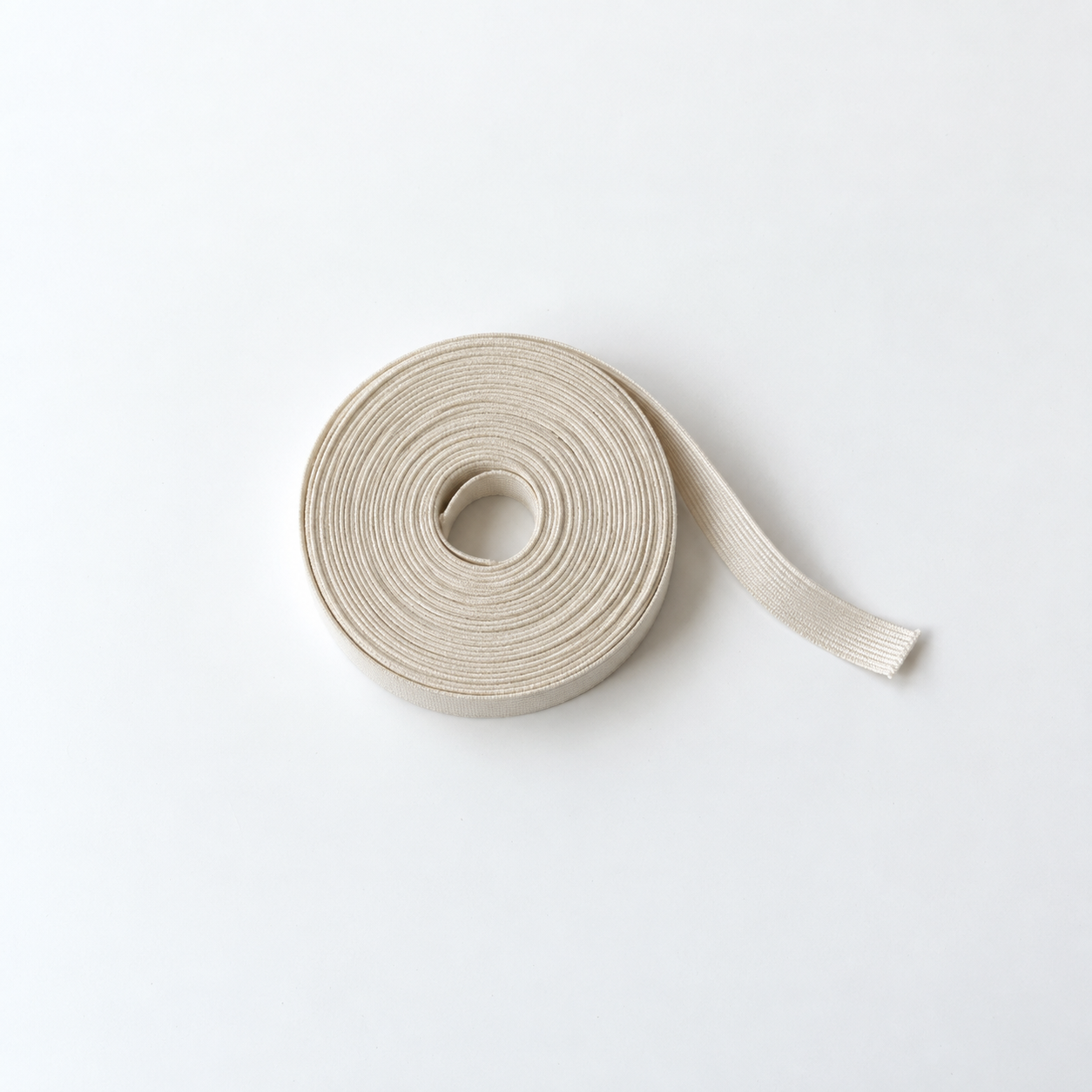 Illustrative flat-lay mockup of an undyed cotton elastic roll on white